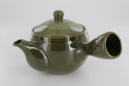 A green tea pot with a handle and lid.