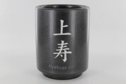 A black cup with the word " hirakugyo " written in japanese.