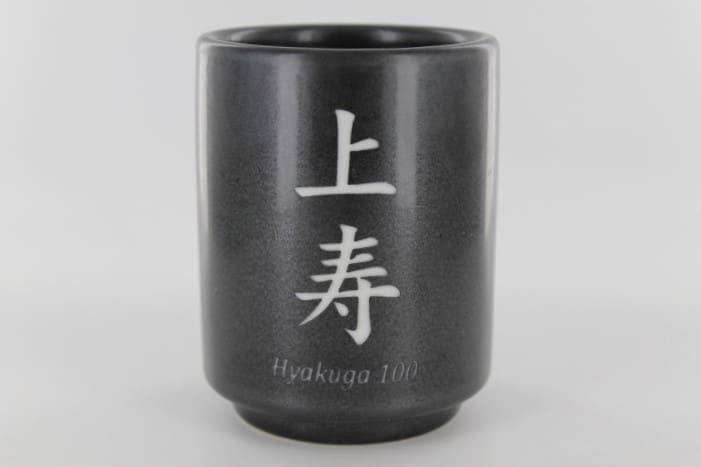 A black cup with the word " hirakugyo " written in japanese.