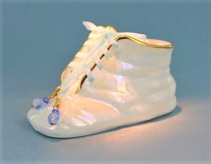 A white shoe with blue and purple beads on it.