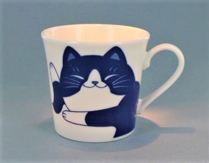 A cat mug with a picture of a black and white cat.