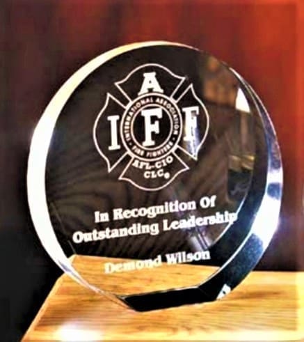 A glass award sitting on top of a wooden table.