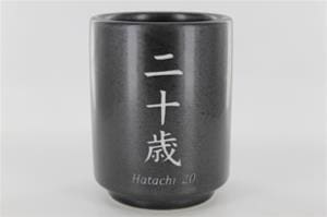 A black cup with the word " hutochi 2 0 " written on it.