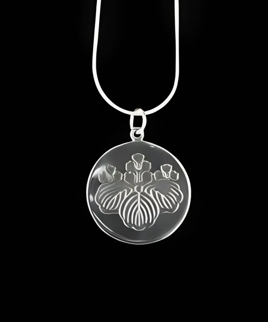 Silver necklace with engraved iris pendant.